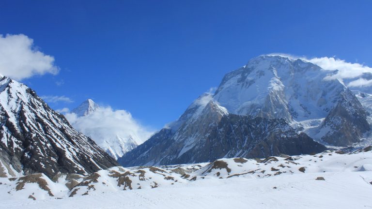 Snow-covered summits of Broad Peak and K2 rising above the Karakoram range