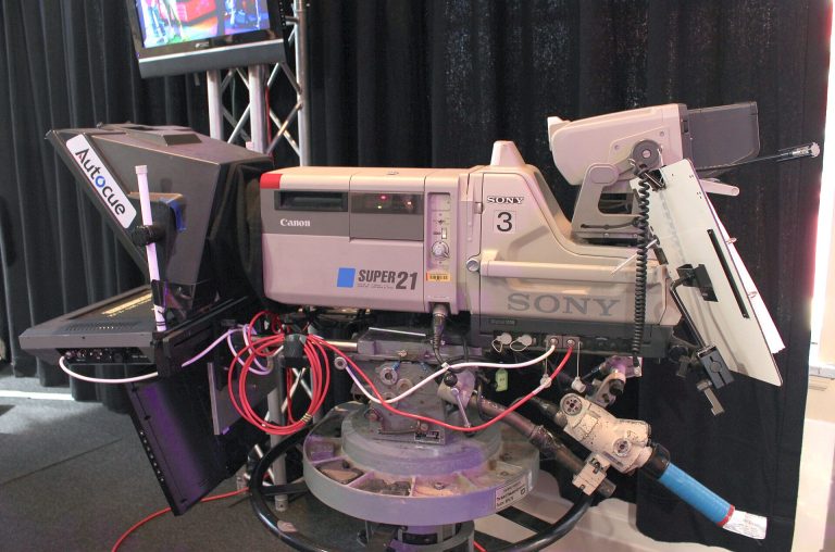 A professional broadcast camera mounted in a television studio