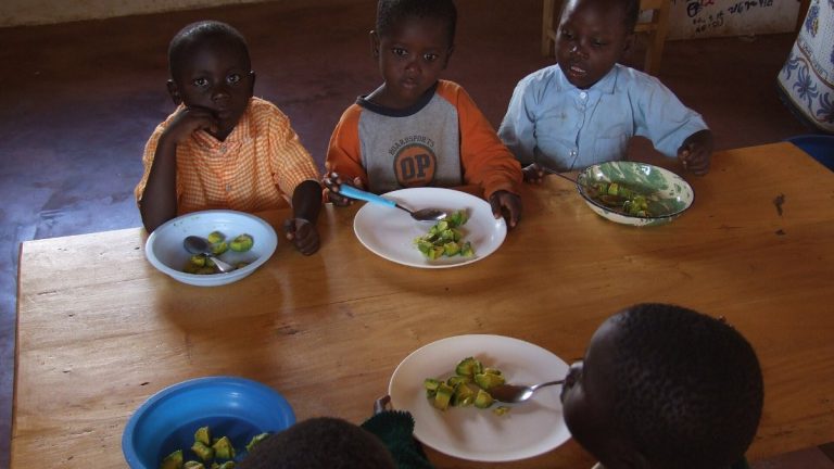 Pupils eat a hot lunch under a county feeding programme.