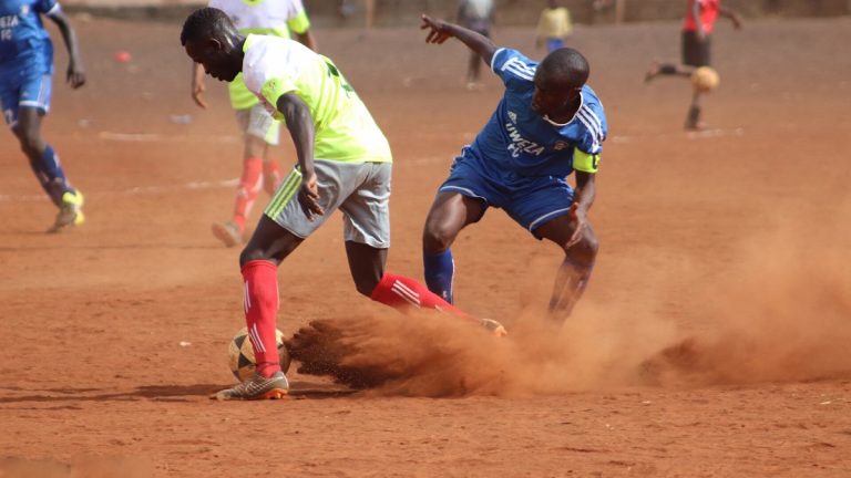 Two footballers challenge for the ball on a dusty pitch (file photo)