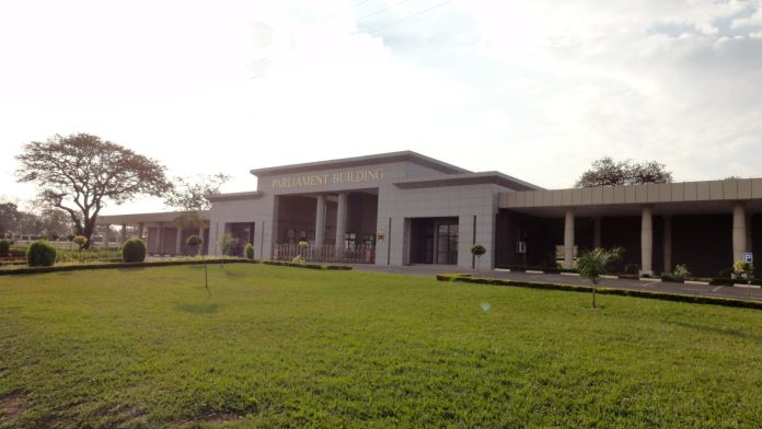 The low white Parliament building of Malawi in Lilongwe behind an open green lawn