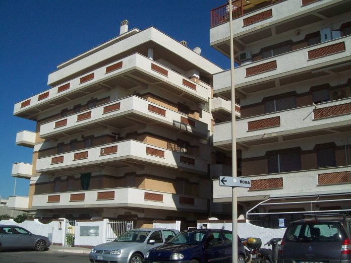 A multi-storey post-war residential apartment block on a street near Rome, Italy