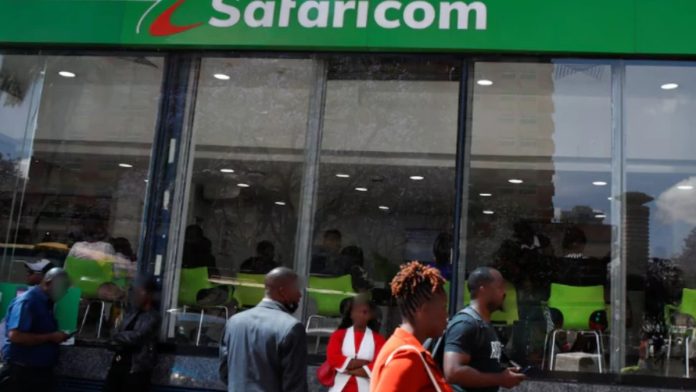 Pedestrians outside a Safaricom customer care centre in Nairobi
