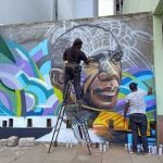 Bankslave painting a mural